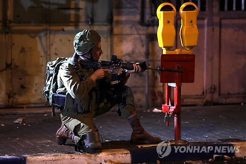 국경 방어 임무를 수행 중인 이스라엘 군인(가자지구 EPA=연합뉴스 제공) 이스라엘 주재 미국대사관이 예루살렘으로 이전한 14일(현지시간) 팔레스타인 가자지구에서 대규모 폭력시위가 벌어진 가운데, 이스라엘 군인이 돌을 던지는 시위대를 향해 발포 자세를 취하고 있다.
