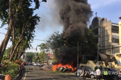 지난 14일 인도네시아 수바라야에 있는 한 개신교회에서 일가족이 벌인 자폭테러로 화염이 치솟는 모습. [AFP=연합뉴스 제공]