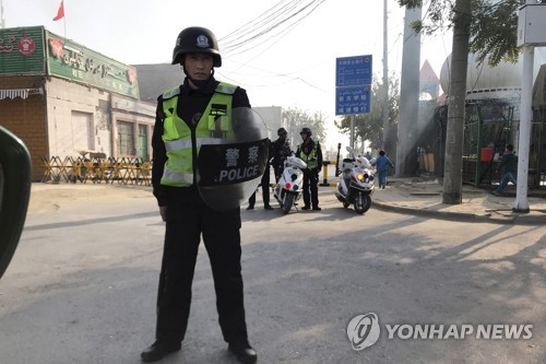신장위구르자치구의 한 거리에서 감시하는 중국 공안 [연합뉴스 제공]