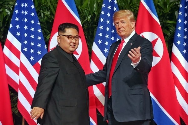 도널드 트럼프 미국 대통령(오른쪽)과 김정은 북한 국무위원장이 12일 미북정상회담 장소인 싱가포르 센토사섬 카펠라 호텔에 도착해 악수를 나눈 뒤 포즈를 취하고 있다.(사진=연합뉴스)