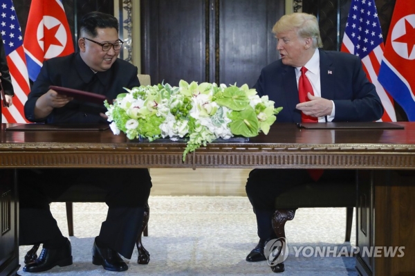 도널드 트럼프 미국 대통령(오른쪽)과 김정은 북한 국무위원장이 지난 12일(현지시간) 싱가포르 센토사섬 카펠라호텔에서 공동합의문 서명식을 진행하고 있다(연합뉴스).