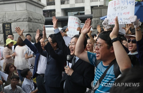 28일 오후 서울 종로구 헌법재판소 앞에서 열린 기자회견에서 참가자들이 특정 종교에 대한 병역거부 혜택을 반대하는 입장을 밝히며 만세를 부르고 있다(연합뉴스).