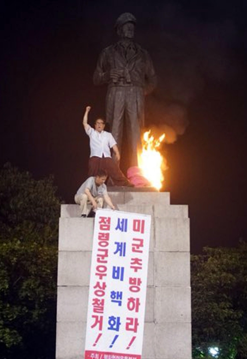 맥아더 장군 동상에 불을 지르는 좌파단체 회원들 [연합뉴스 제공]