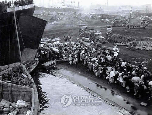 1950년 12월19일 흥남에서 출발하는 LST(Landing Ship, Tank)에 타기 위해 몰려든 북한 피난민들. 피난민 뒤로 야적돼 있는 미군의 포탄이 보인다.(사진=연합뉴스)