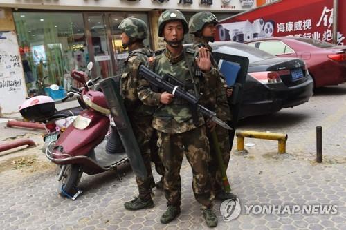 중국 신장 자치주의 한 쇼핑몰 앞에 무장 경찰관들이 서 있다 [연합뉴스 제공]