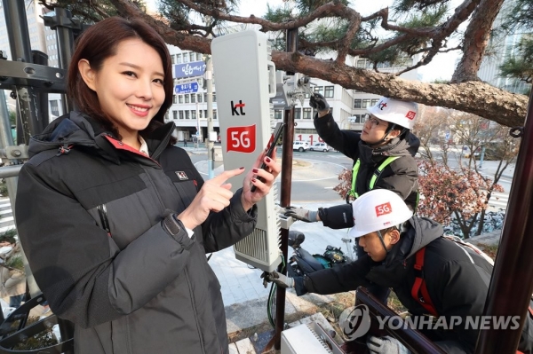 지난 30일 KT 직원들이 광화문에 설치된 5G 기지국을 점검하며 삼성 5G 스마트폰 시제품을 테스트하고 있다. (사진 = 연합뉴스)