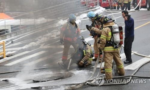 24일 오전 지하 통신구에서 화재가 발생한 서대문구 충정로의 KT 아현빌딩 앞에서 소방대원들이 화재진압 작업을 벌이고 있다.