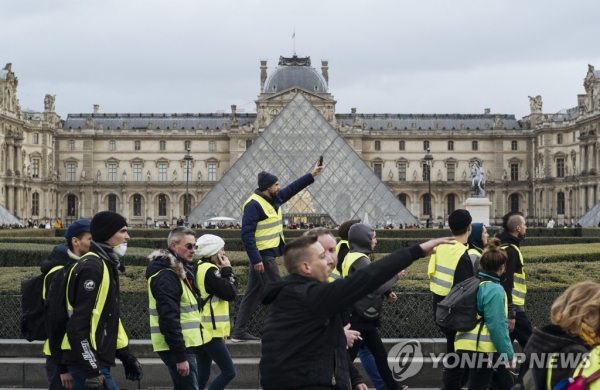 22일 프랑스 파리 중심가의 노란 조끼 집회 참가자들. (사진 = 연합뉴스)