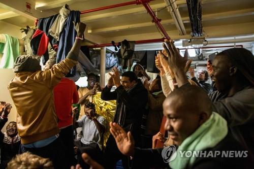 독일 NGO의 선박 '씨 워치3'에 타고 있던 북아프리카인들이 9일 몰타에 내릴 수 있게 됐다는 소식을 들은 뒤 환호하고 있다. [AFP=연합뉴스 제공]