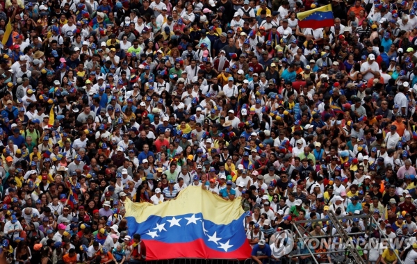 니콜라스 마두로 대통령의 퇴진을 요구하는 반정부 집회 참가자들이 국기를 들고 있다. [로이터=연합뉴스 제공]