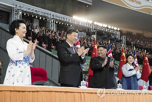 20일 평양 능라도 5·1 경기장에서 방북 중인 시진핑 중국 국가주석과 부인 펑리위안 여사(왼쪽)가 김정은과 부인 리설주와 함께 집단체조와 예술공연 관람 중 자리에서 일어나 박수치고 있다.