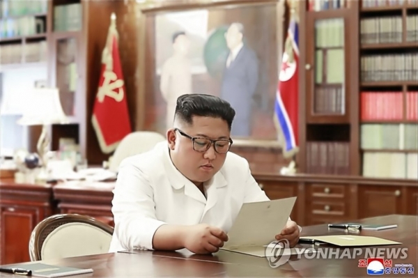 조선중앙통신이 23일 홈페이지에 공개한 사진에서 북한 김정은이 집무실로 보이는 공간에서 트럼프 대통령의 친서를 읽는 모습 [연합뉴스 제공]