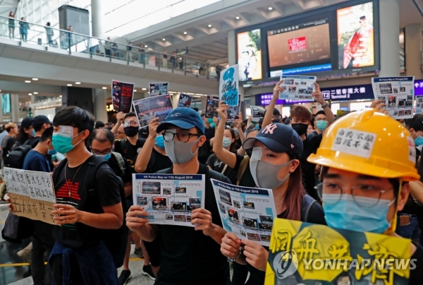 12일 홍콩국제공항을 점거한 시위대. 전날 침사추이에서 집회에 참석한 여성 시위자가 경찰이 발포한 '빈백건'에 맞아 오른쪽 눈이 실명 위기에 처한 가운데 시위 참가자들이 흰색 안대를 착용하며 시위를 이어가고 있다. [연합뉴스 제공]