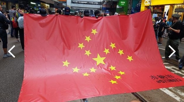 31일 송환법 반대 시위에 나온 시위 참가자들이 중국 오성홍기와 나치 문양을 결합해 만든 깃발을 들어보이고 있다./연합뉴스