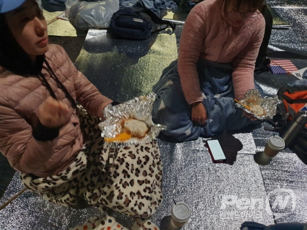 청와 대 앞 철야농성 참가자들이 주먹밥으로 저녁식사를 하고 있다(사진=양연희).
