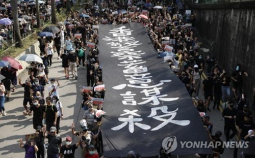 '홍콩 경찰이 짐승처럼 사람을 죽인다'고 쓴 플래카드를 들고 있는 홍콩 시위대./