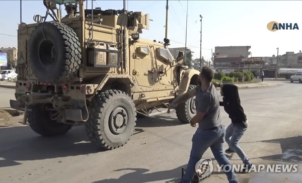 10월21일(현지시간) 시리아 북부 까미슐리에서 철수하는 미군 차량에 감자와 돌멩이를 던지는 쿠르드인들.(사진=연합뉴스)