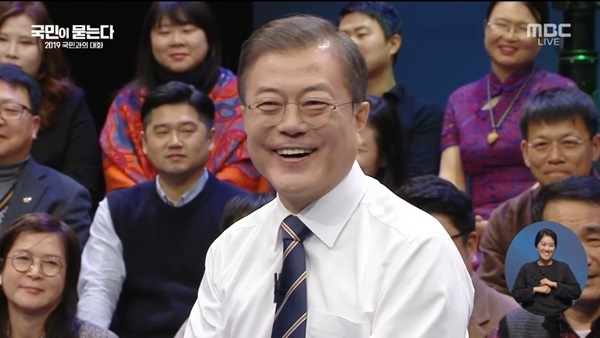 문재인 대통령이 11월19일 오후 8시부터 117분간 진행된 MBC 생방송 '국민과의 대화'에서 질문 답변 도중 웃고 있다.(사진=MBC 유튜브 생방송 캡처)<br>