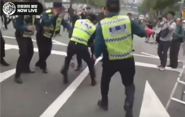 서초동 집회 당시 달려가는 안정권 대표를 발로 걸어 넘어뜨리는 경찰. (사진 = SNS 캡처)