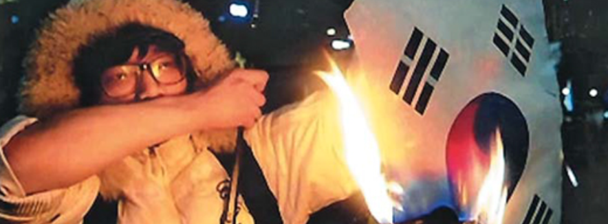 2015년 집회에서 태극기를 불태우고 있는 A씨. (사진 = 채널A 방송화면 캡처)
