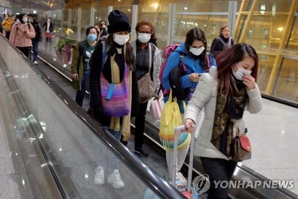 지난 1월25일 중국 베이징 공항에 도착한 여행객들이 마스크를 쓴 채 에스컬레이터를 타고 이동하고 있다.(사진=연합뉴스)