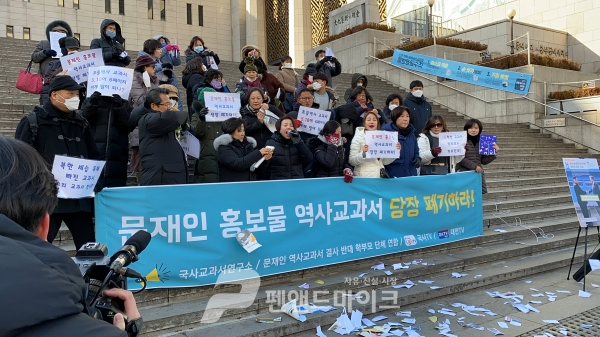 전국학부모단체연합 관계자들이 6일 서울 세종문화회관 앞에서 좌편향 논란 교과서를 찢는 퍼포먼스를 벌이고 있다. (사진 = 김종형 기자)