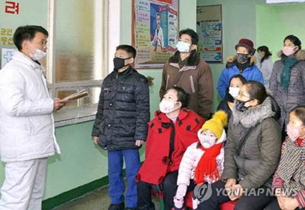 북한 평양 소재 대동강구역인민병원의 의료진이 마스크를 쓴 주민들에게 예방수칙 등을 안내하고 있는 모습.(사진=연합뉴스)