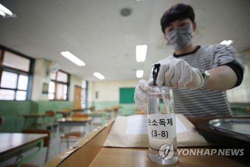 고3 등교 개학을 이틀 앞둔 18일 서울 경복고등학교에서 한 교사가 손 소독제를 비치하고 있다.(사진=연합뉴스)