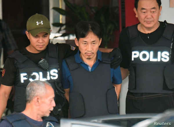 김정남 암살 사건 용의자로 말레이시아 경찰에 의해 체포됐던 리정철이 2017년 3월 쿠알라룸푸르 세팡 경찰서에서 방탄조끼를 입은 채 공항으로 향하는 차에 오르고 있다. 리정철은 이날 북한으로 추장됐다(VOA).