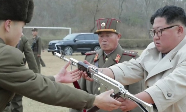 지난해 11월 창린도 방어부대를 시찰하며 한 부대원에 총을 건네는 북한 김정은.(사진=연합뉴스)