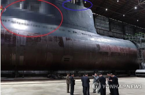 조선중앙TV는 김정은 시찰 장면이 담긴 사진을 공개하면서 잠수함에서 SLBM 발사관이 있을 것으로 추정되는 부분(붉은 원)과, 함교탑 위 레이더와 잠망경 등이 위치했을 것으로 추정되는 부분(파란 원)을 각각 모자이크 처리했다. (연합뉴스)