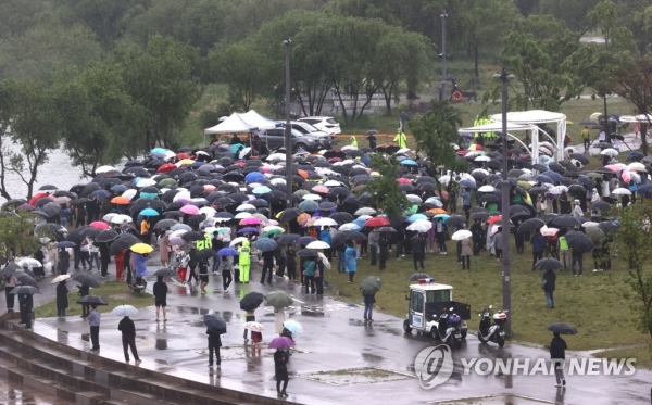 지난 16일 오후 서울 반포한강공원 수상택시 승강장 인근에서 열린 '고 손정민 군을 위한 평화집회'에서 참가자들이 우산을 쓴 채 자리를 지키고 있다. [연합뉴스 자료사진]