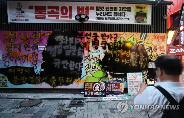지난달 31일 서울 종로구 소재 중고서점에 설치된 벽화에 검정 페인트칠이 칠해졌다.(사진=연합뉴스)