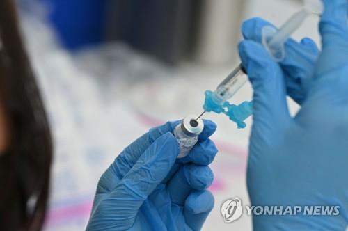 한 의료진이 화이자 백신을 주사기에 옮기고 있다. [AFP=연합뉴스 자료사진]