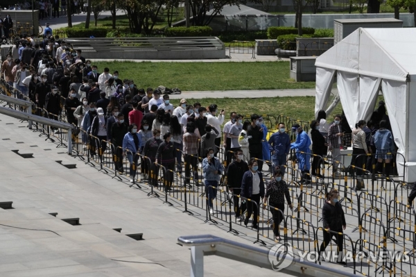 26일 중국 수도 베이징의 하이뎬구에 설치된 코로나19 검사소 앞에 시민들이 길게 줄지어 서 있다. 베이징시는 코로나19 확산 차단을 위해 전체 시민(2천188만 명)의 90%에 대해 PCR 검사를 시행할 방침이다. [사진=연합뉴스]