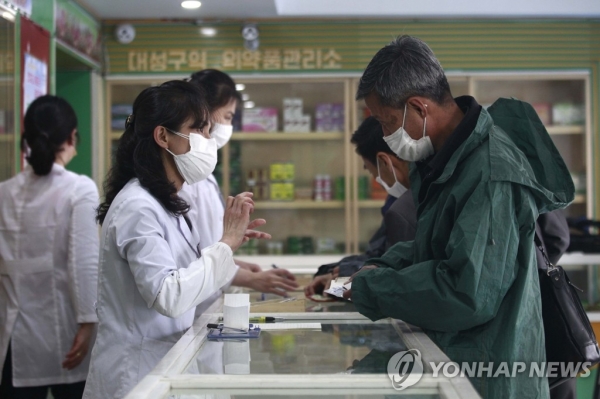 북한 평양의 대성구에서 16일 의약품관리소(약국) 직원들이 주민들에게 약을 처방해주고 있다. 조선중앙통신에 따르면 최근 북한에서 코로나19가 급속하게 확산하는 가운데 이날 신규 발열자는 26만9천여 명, 사망자는 6명이 발생한 것으로 집계됐다. 2022.5.17