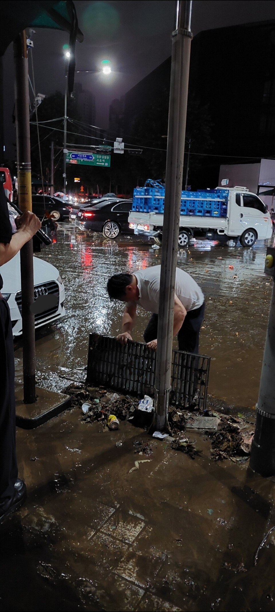한 중년 남성이 8일 밤 집중 호우로 물이 범람한 강남역에서 배수로를 치우는 모습이 포착됐다. 이 사진을 인터넷에 올린 네티즌은 이 남성을 '슈퍼맨'이라 칭했다. [사진=에펨코리아]