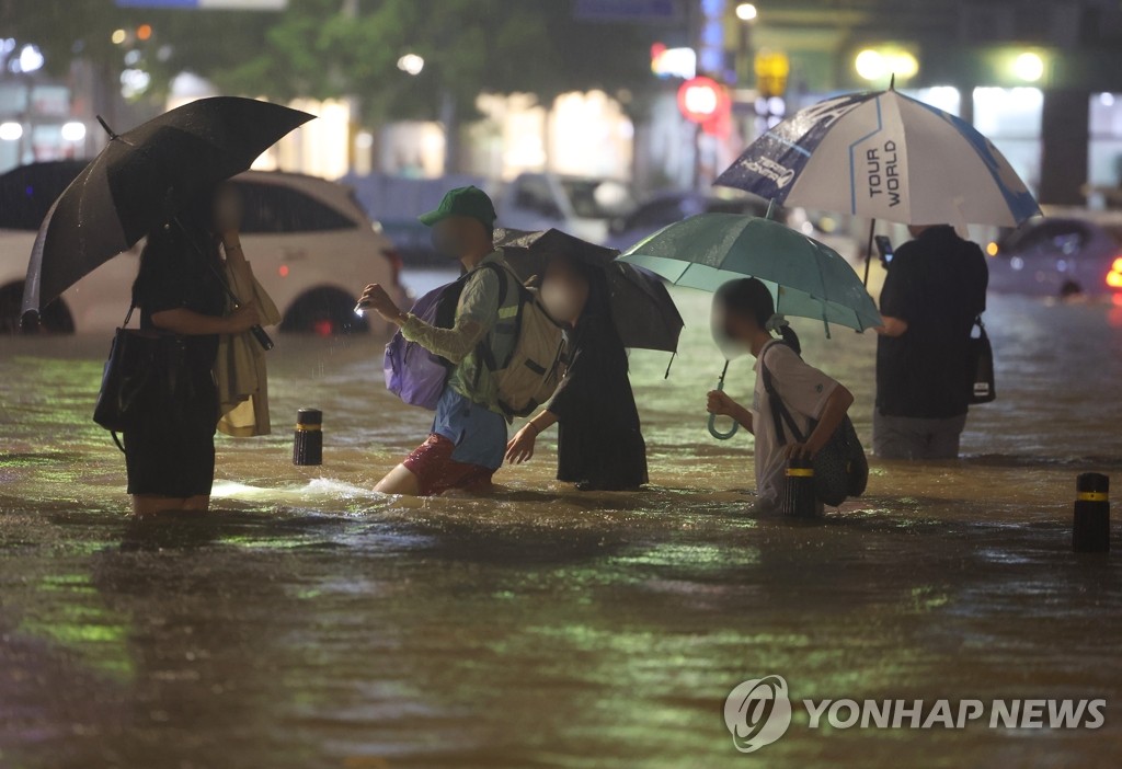 8일 밤 서울 강남구 대치역 인근 도로와 인도가 물에 잠기면서 차량과 보행자들이 통행하는 데 불편을 겪고 있다. 2022.8.8(사진=연합뉴스)