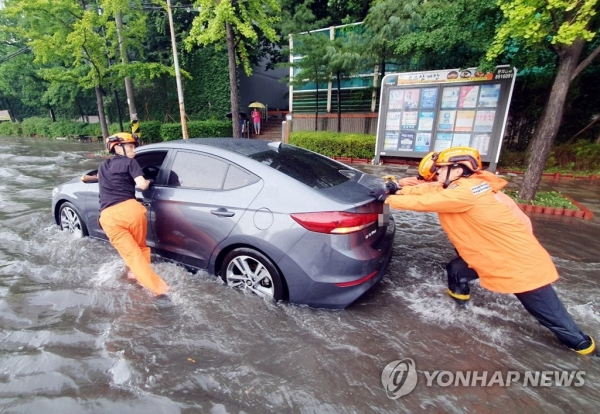 인천지역에 폭우가 내린 8일 인천시 미추홀구 용현동 한 도로에서 소방대원들이 침수된 차량을 안전한 곳으로 옮기고 있다. [사진=연합뉴스]