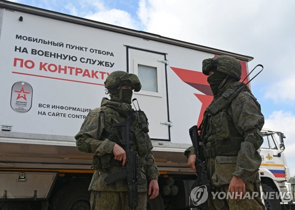 러시아군이 우크라이나 인접지역의 신병 모집센터 옆에 서 있는 모습. [사진=연합뉴스]