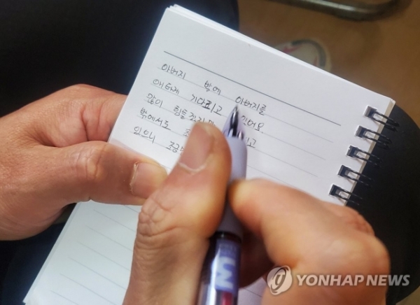 고립된 작업자 박 씨(62)의 첫째 아들 박근형(42)씨가 아버지의 극적인 생환을 기원하며 편지를 작성하고 있다 (사진=연합뉴스)