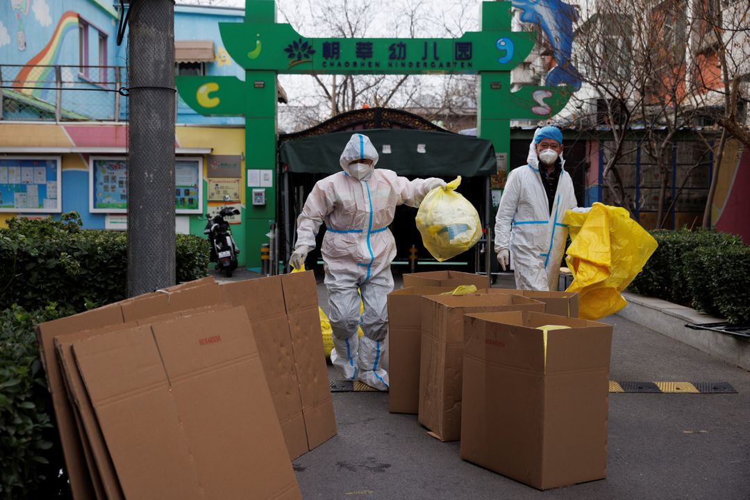 27일(현지시각) 중국 베이징의 한 공원 앞에서 방역복을 입은 작업자가 쓰레기를 정리하고 있는 모습. [사진=로이터]