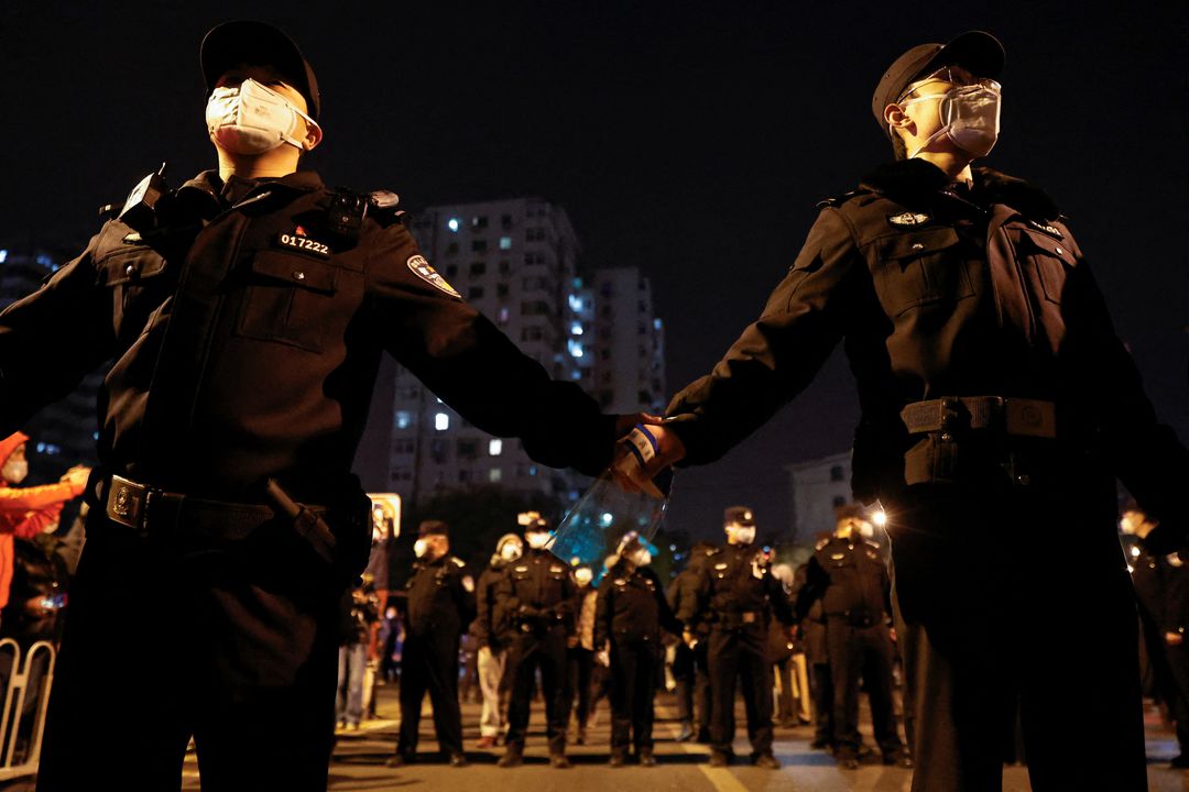 27일(현지시각) 중국 주요 도시들에서 '코로나19 제로' 조치를 반대하는 시위가 일어났다. 이 여파를 차단하고자 중국 공안들이 손을 잡고 있는 모습. [사진=로이터]