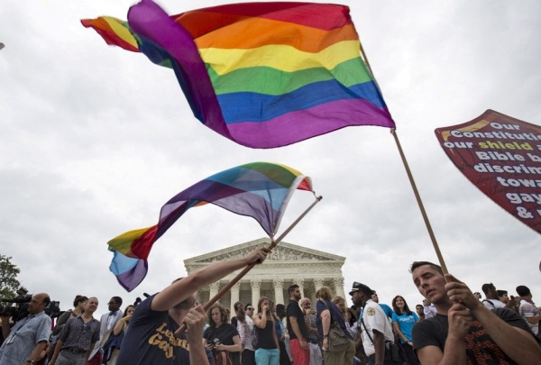 동성애를 상징하는 깃발을 흔들고 있는 동성결혼 지지자들