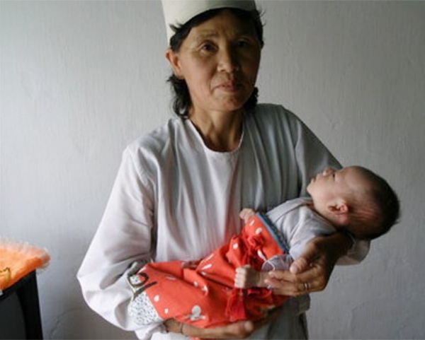 함경북도 청진시 보육원에서 영양실조에 걸린 어린이를 안고 있는 보모.(사진=RFA)