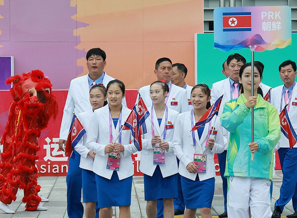 2022 항저우 아시안게임(AG) 개막을 하루 앞둔 22일 북한 선수단이 중국 항저우시 아시안게임 선수촌 국기광장에서 열린 공식 입촌식에 참석해 입장하고 있다.  [연합뉴스]