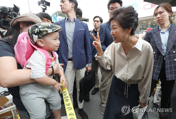 박근혜 전 대통령이 25일 낮 대구 달성군 사저 인근에 있는 현풍시장을 찾아 주민들을 만나고 있다./연합뉴스