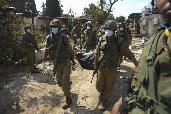 지난 10일(현지시간) 이스라엘 군인들이 하마스 공격으로 사망한 시신을 운반하고 있다. [AP연합]