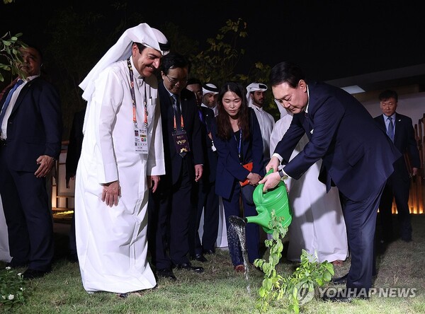 윤석열 대통령이 24일(현지시각) 카타르 도하에서 열린 도하 국제원예박람회에 참석해 카타르 국왕이 선물한 나무에 물을 주고 있다. [사진=연합뉴스]