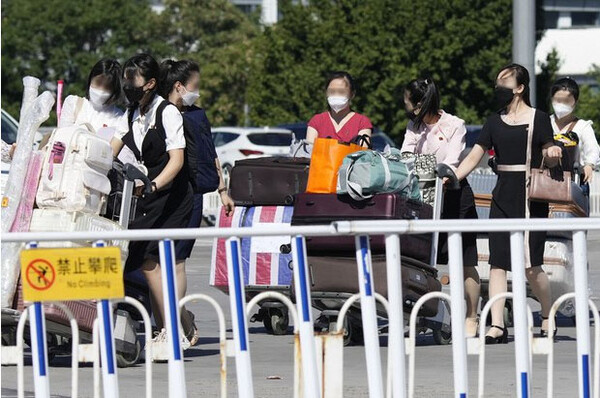 지난 8월 중국 베이징 서우두 공항에서 출국을 위해 터미널로 향하는 북한 여성들. [연합뉴스]